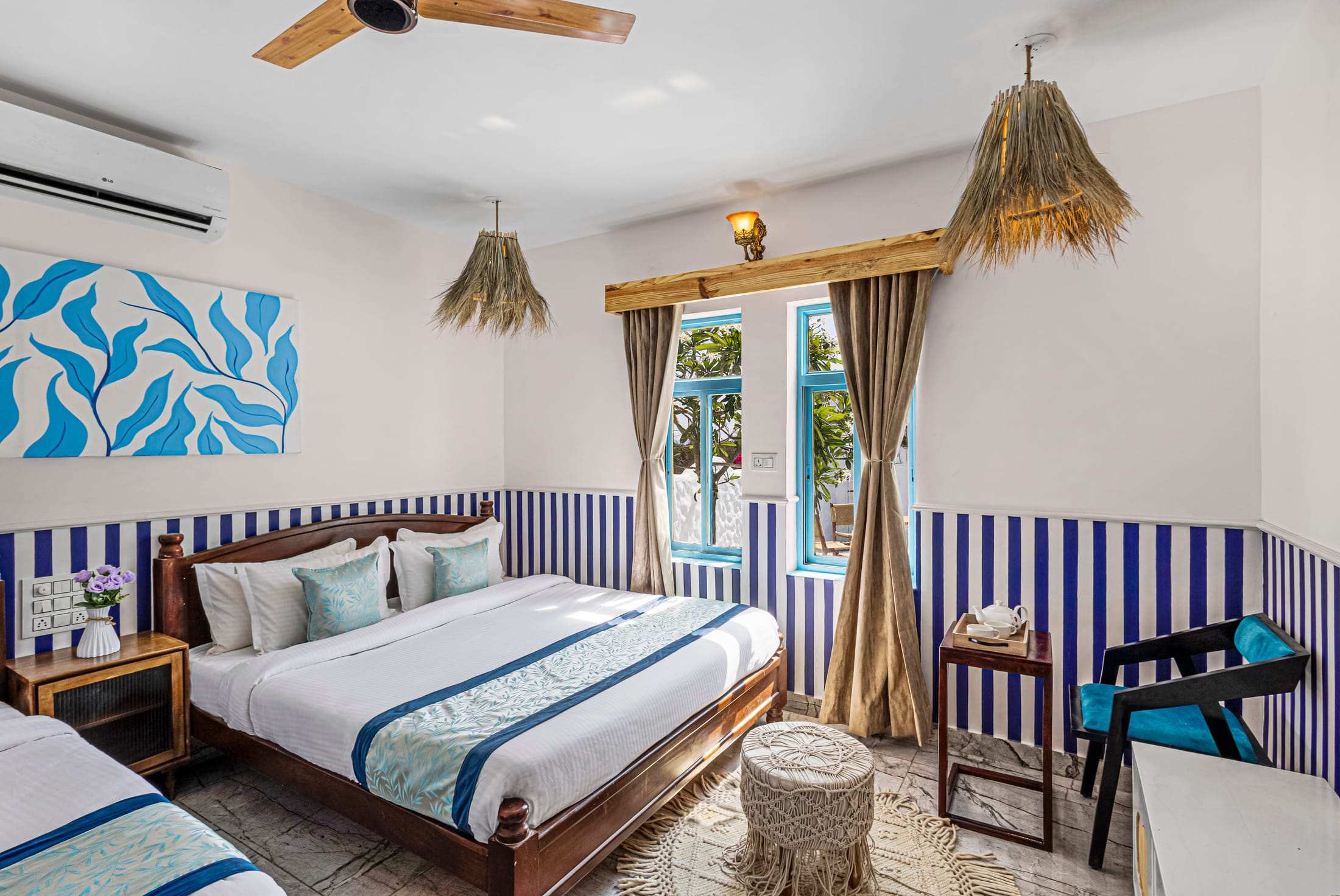Athena's Alcove bedroom with blue and white striped walls, curtains and a seating corner