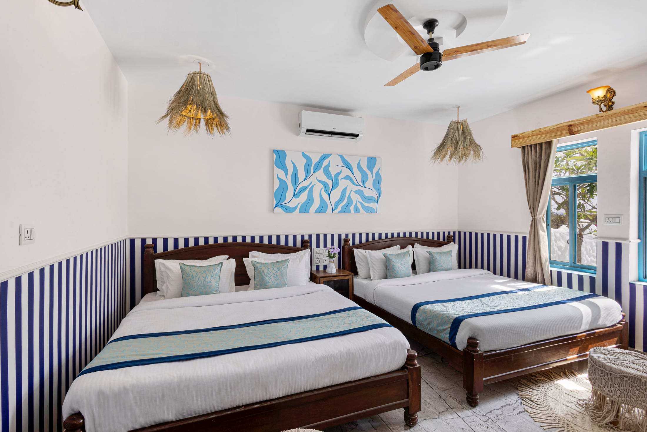 Athena's Alcove with two king beds, striped navy walls and wicker pendant lamps