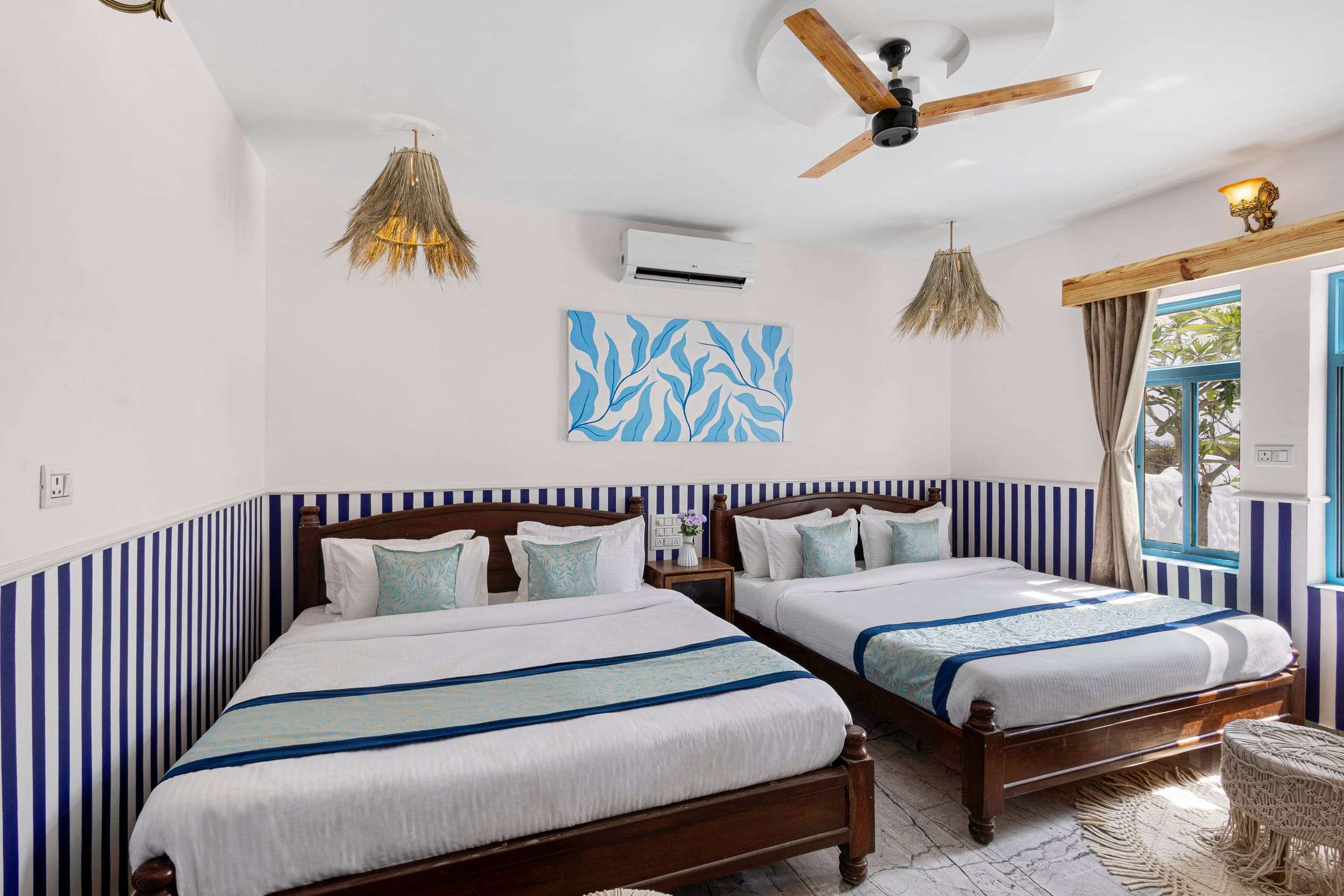 Athena's Alcove with two king beds, striped navy walls and wicker pendant lamps