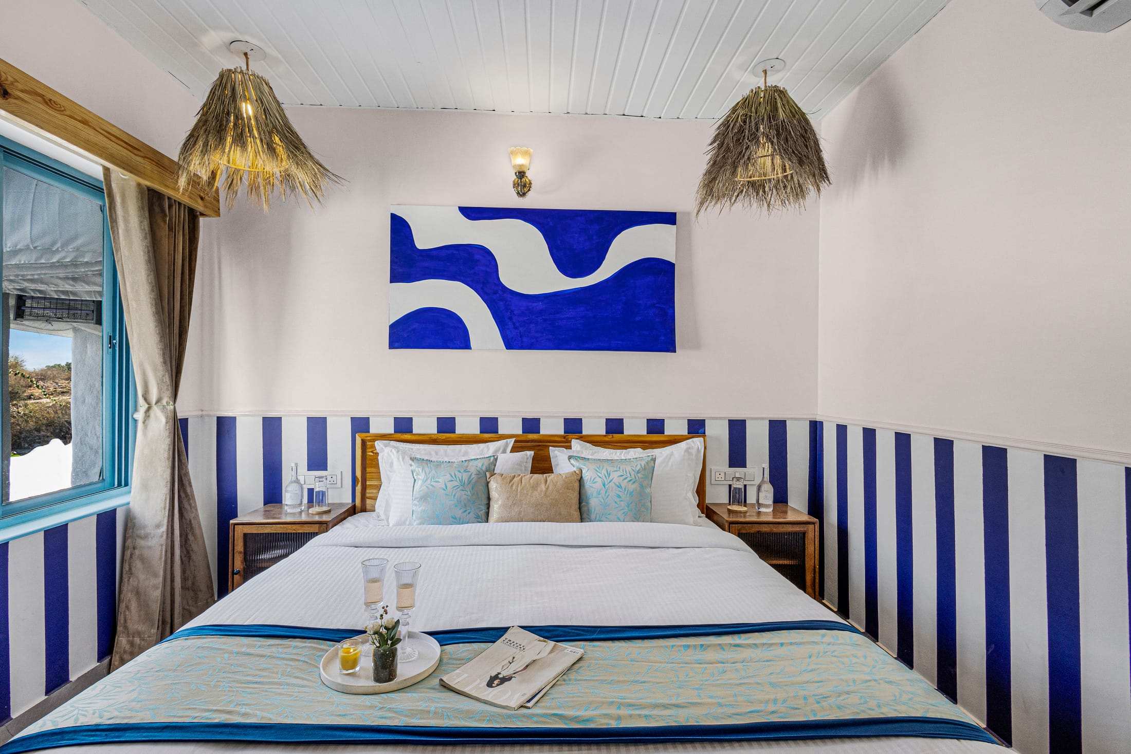 Blue & White Retreat bedroom with curtains, wooden bed and abstract blue art