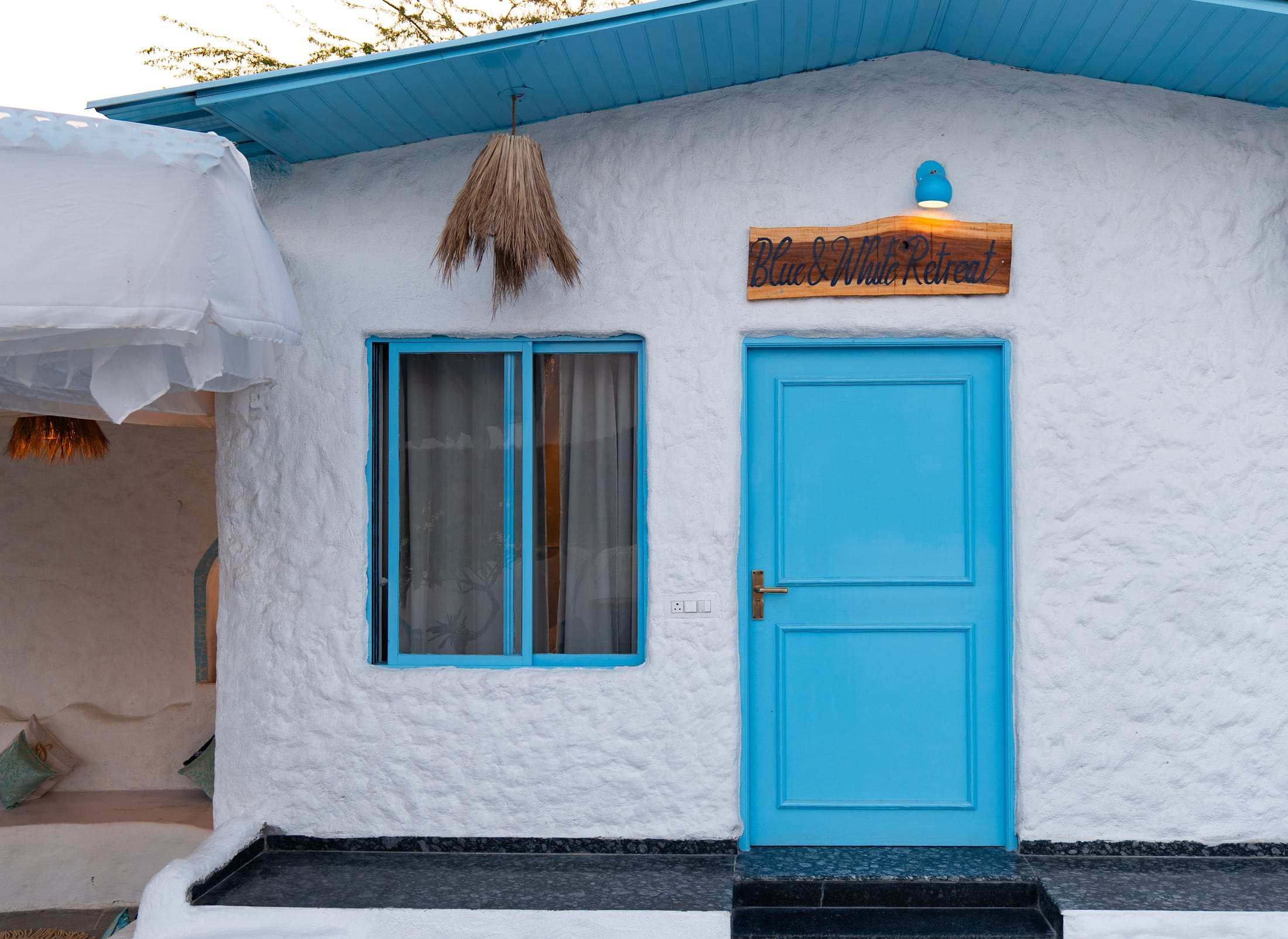 Turquoise door and window of the Blue & White Retreat on the whitewashed wall