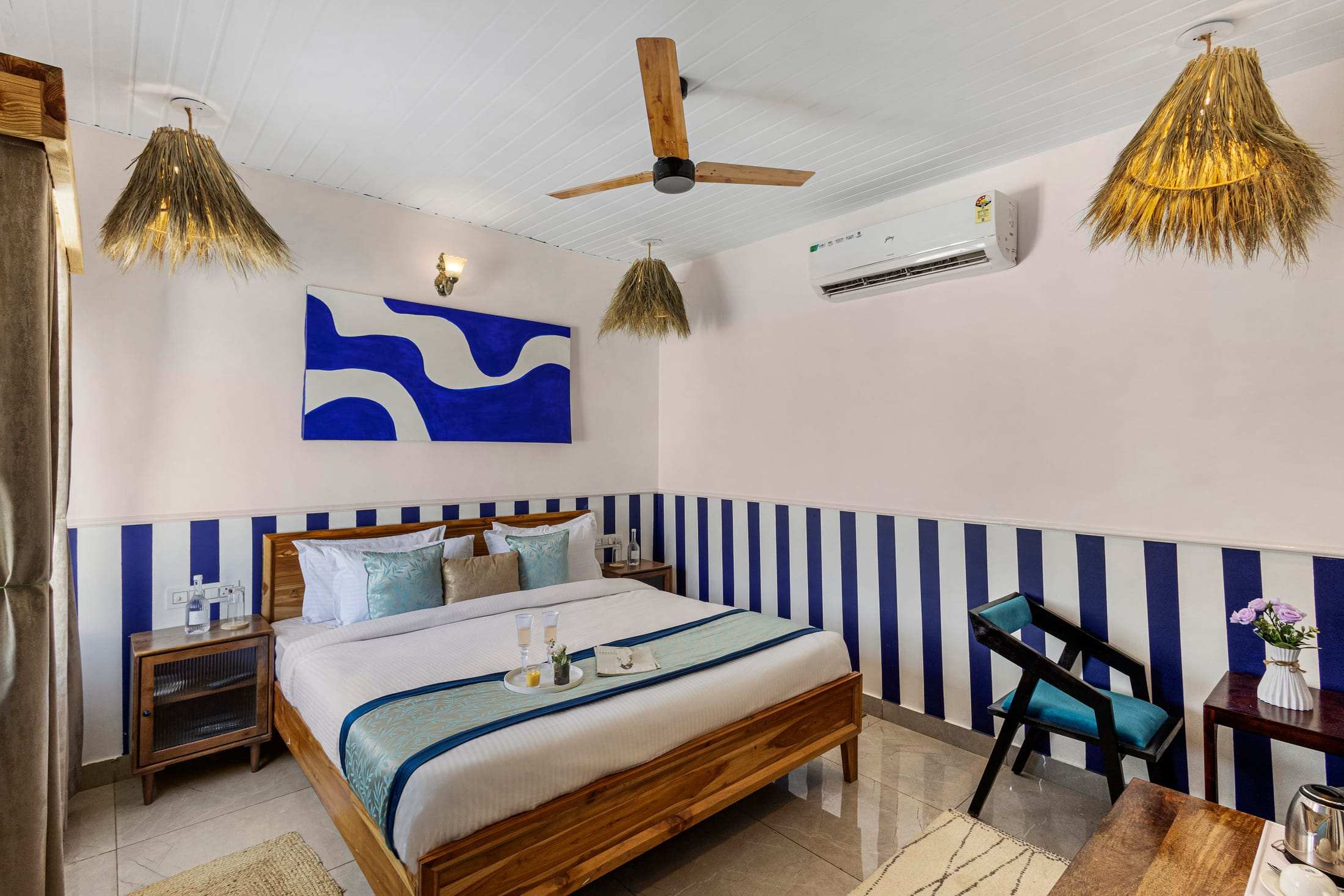 Blue & White Retreat king bed with a bold blue wave painting and striped walls