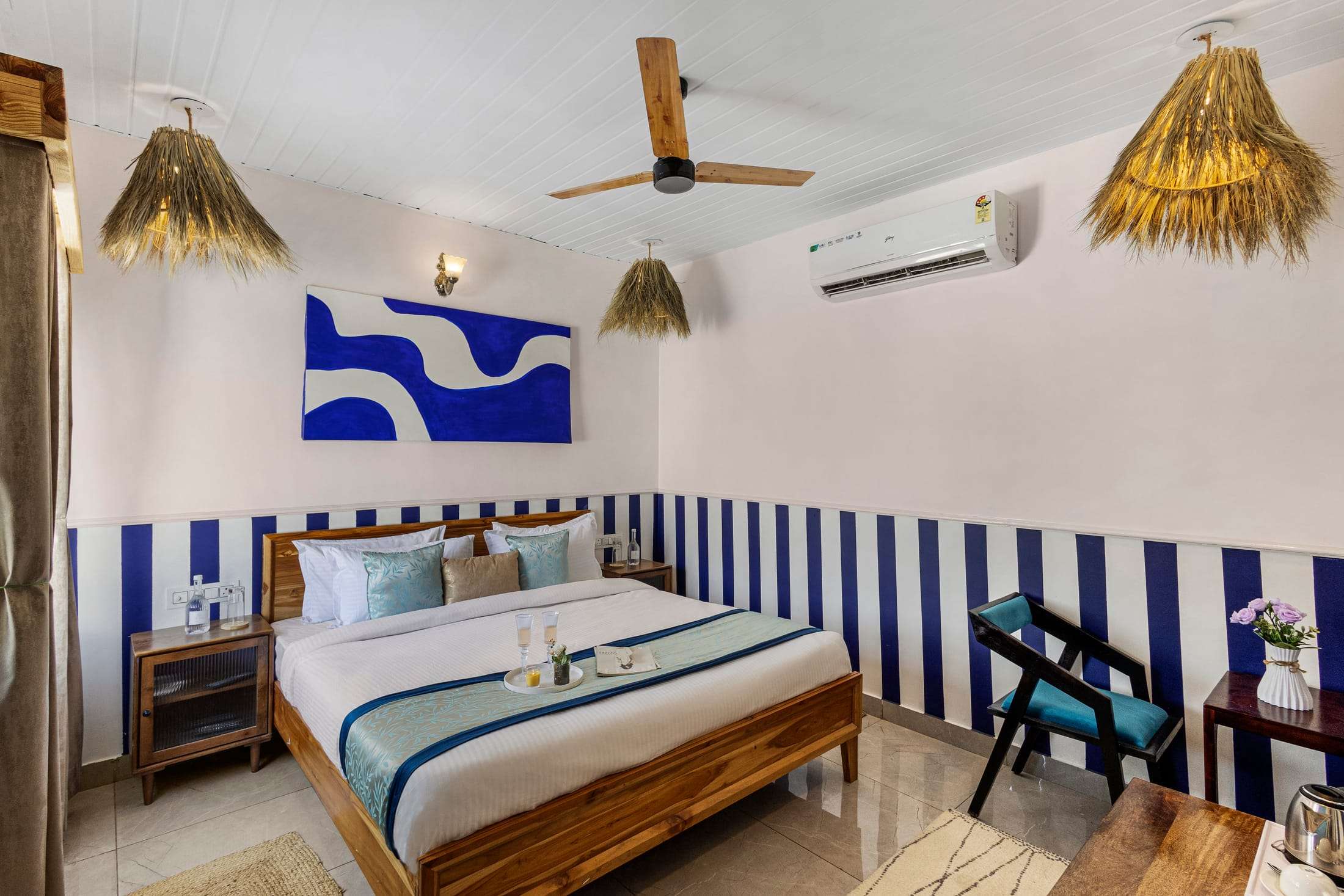 Blue & White Retreat king bed with a bold blue wave painting and striped walls