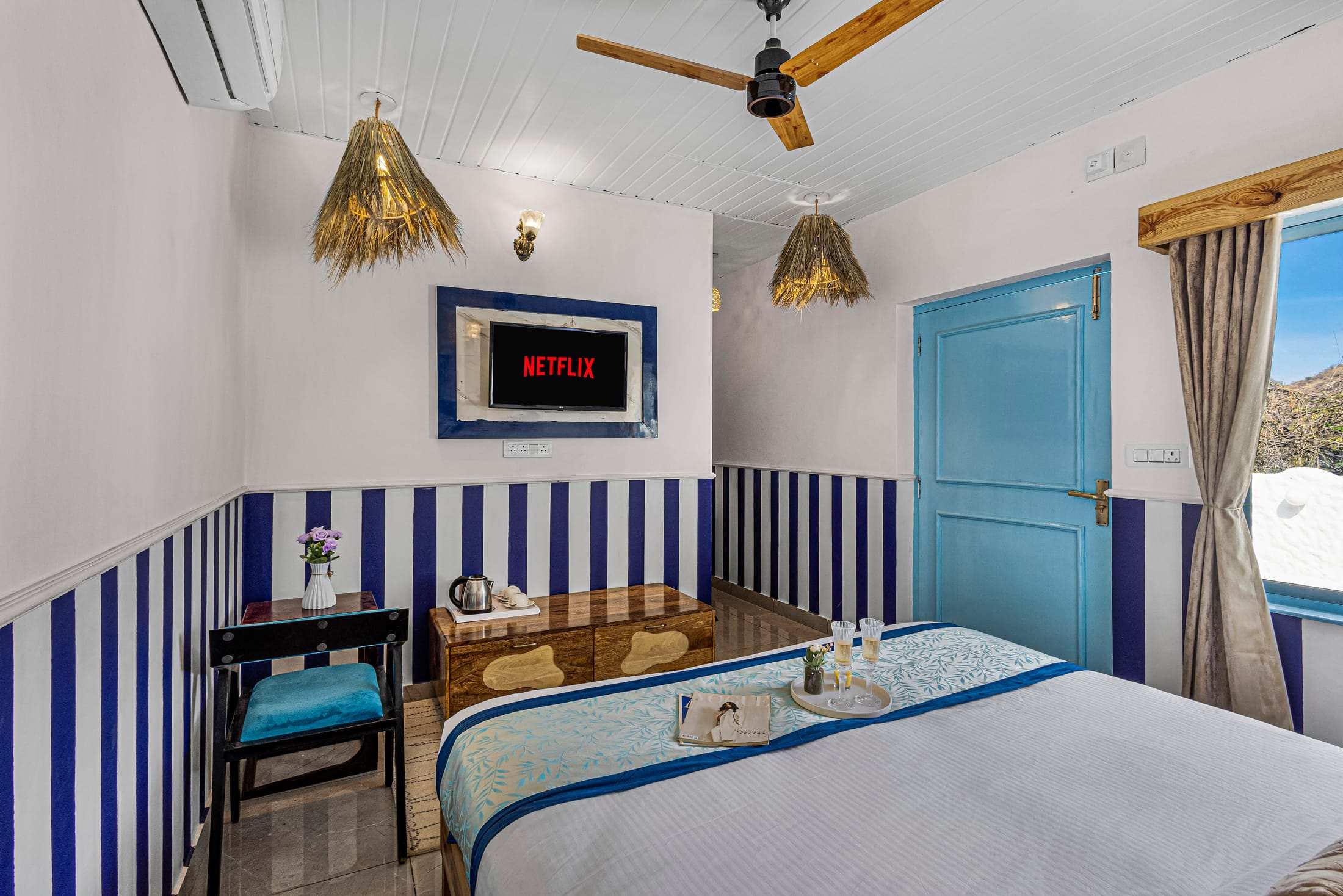 Television and writing desk with a blue chair in the Blue & White Retreat