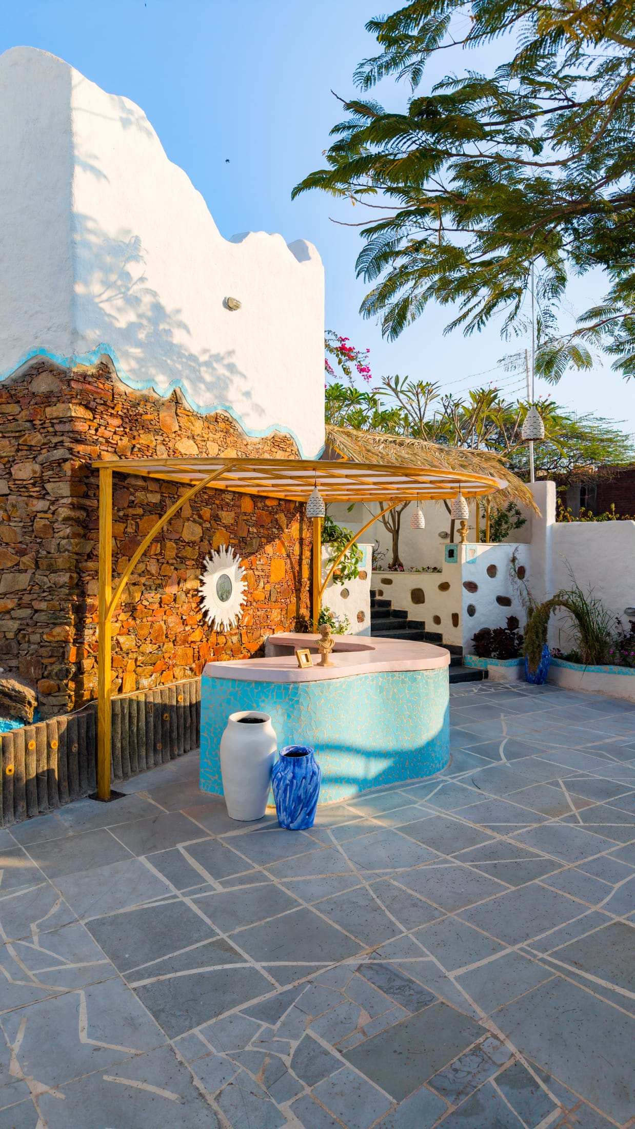 Courtyard with a turquoise fountain, bamboo pergola and stone wall from above