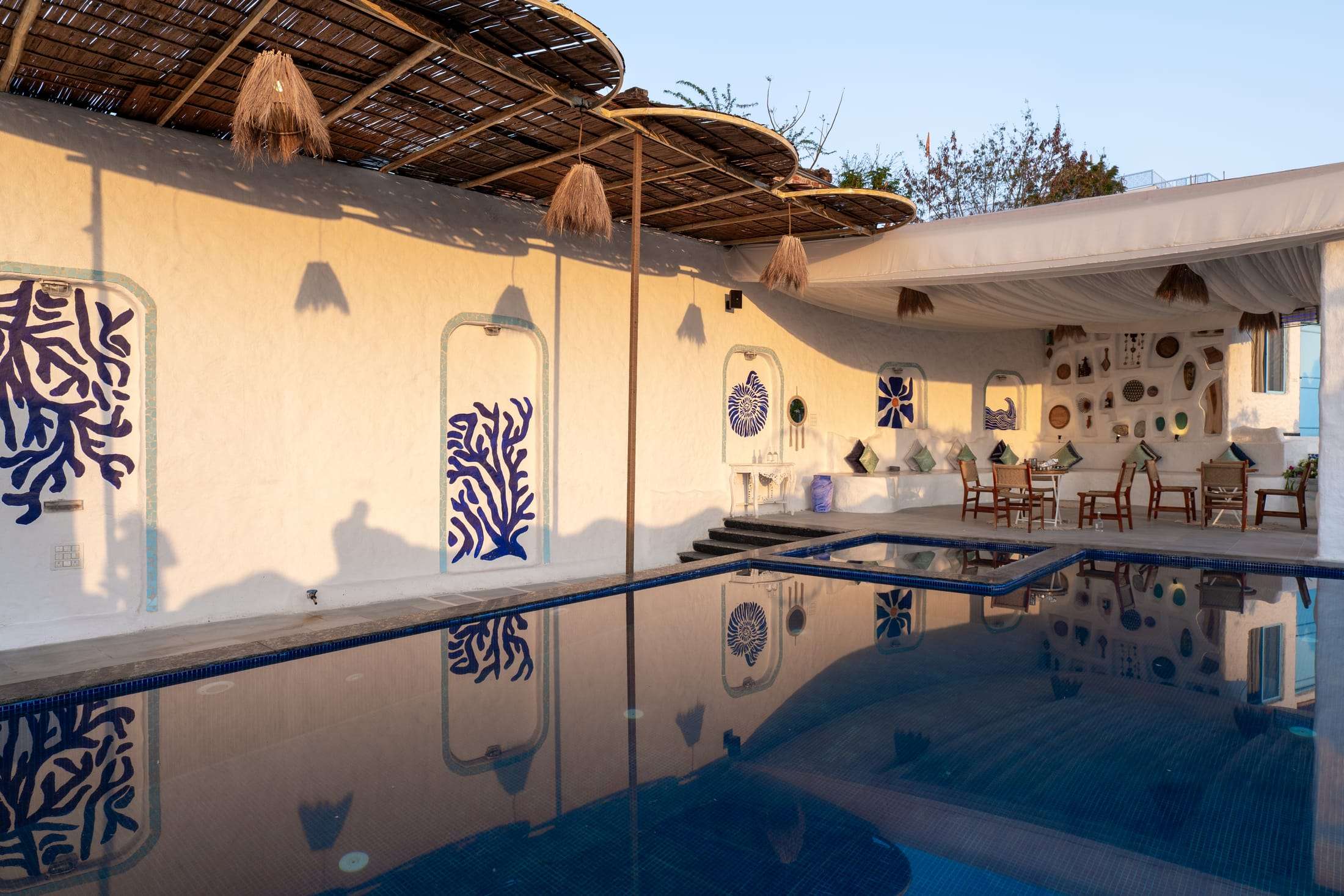 Golden hour light across the pool and white pavilion