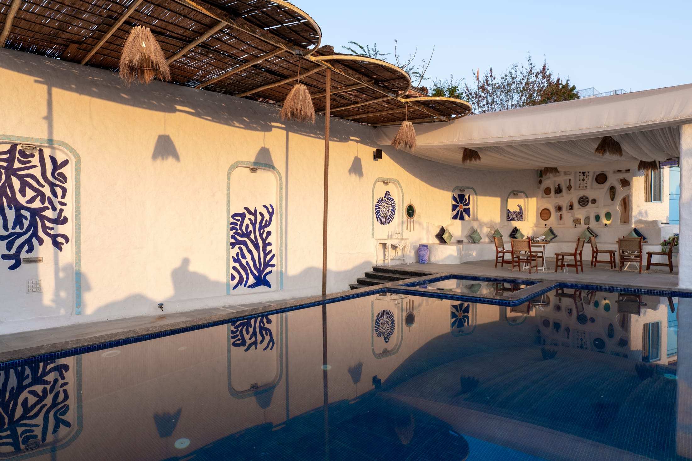 Golden hour light across the pool and white pavilion