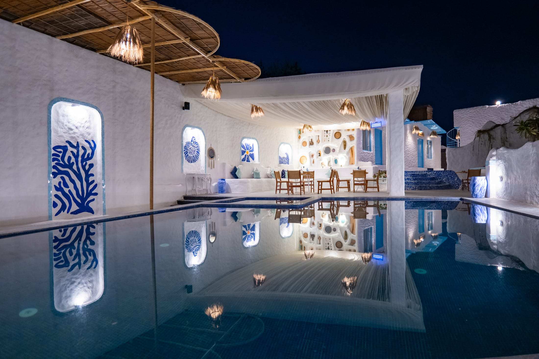 Lit pool pavilion glowing against the night sky