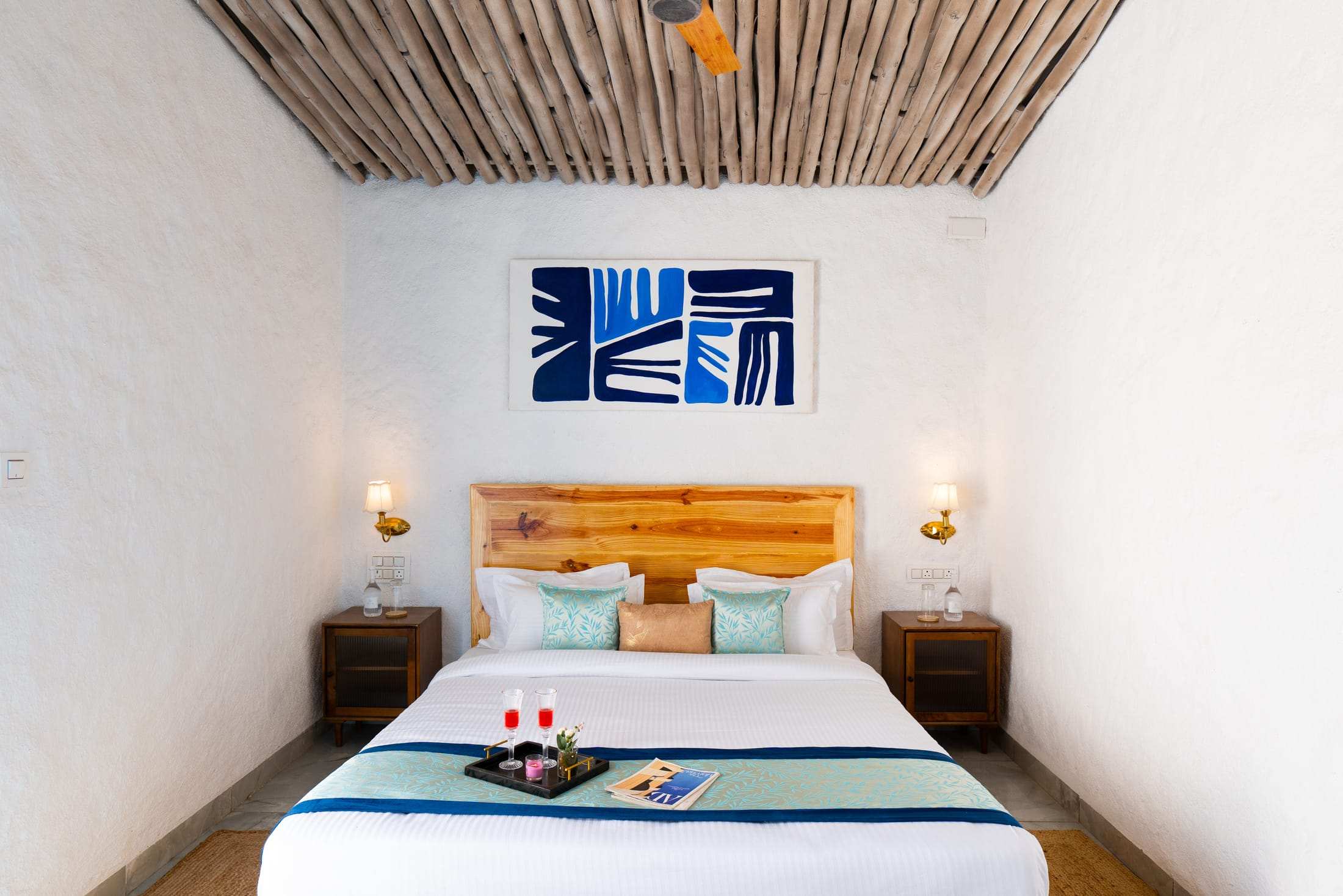 Santorini Suite bed with wall sconces and blue artwork