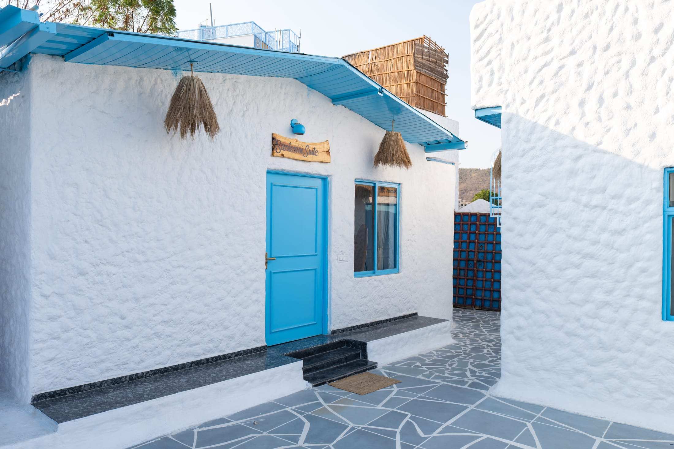 Blue entrance door of the Santorini Suite with thatch accents
