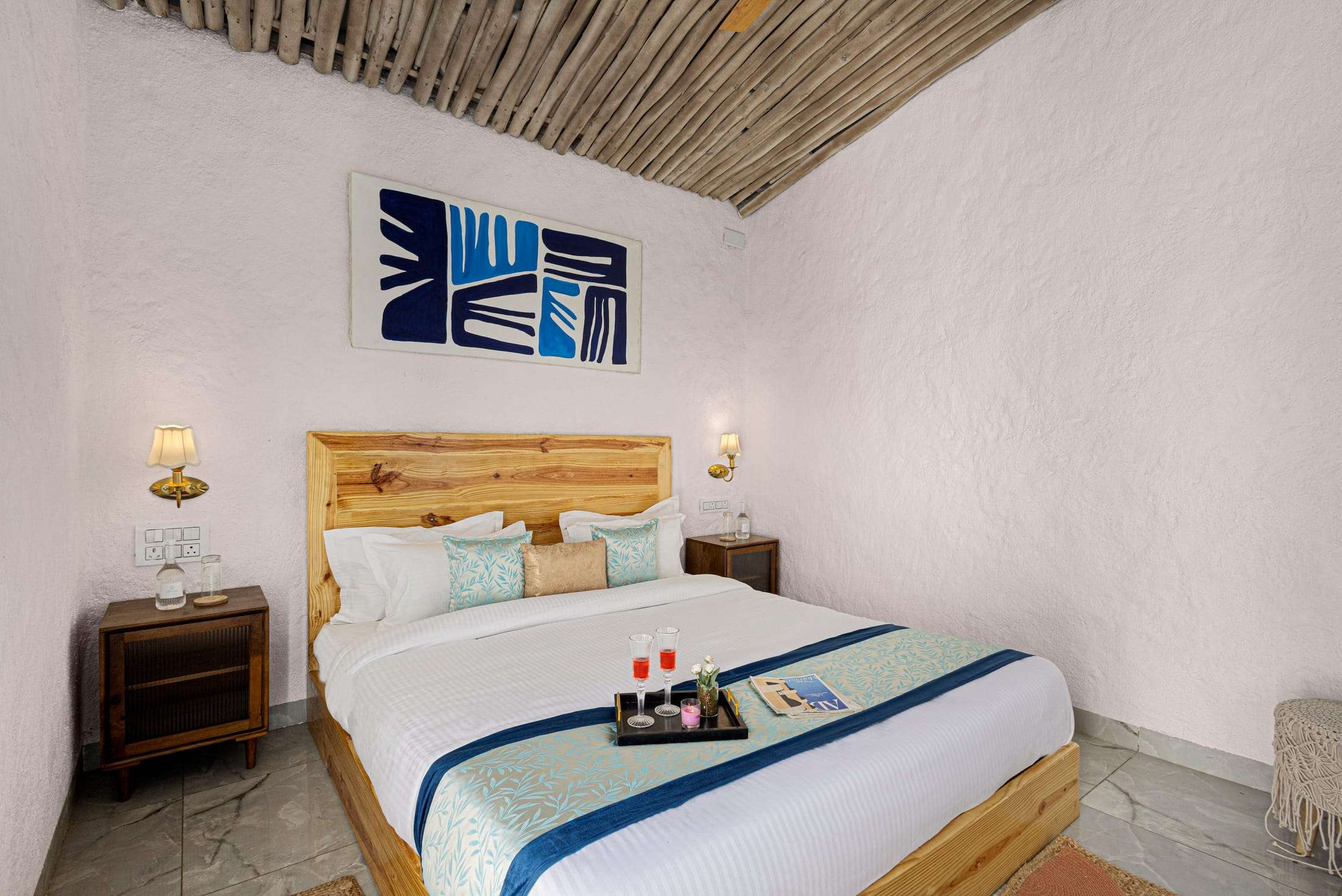 Santorini Suite king bed with a wooden headboard and blue graphic art