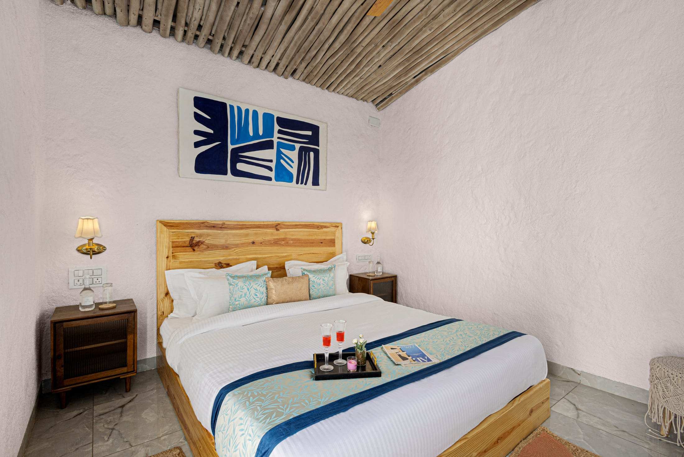 Santorini Suite king bed with a wooden headboard and blue graphic art
