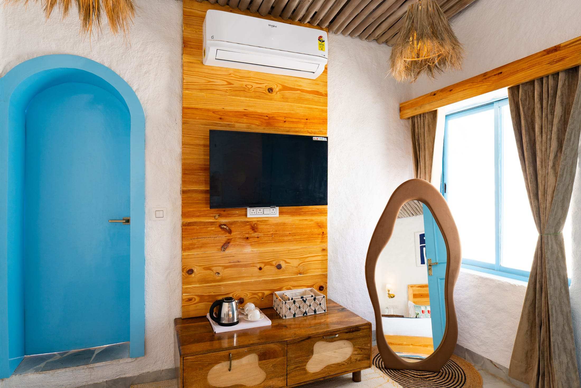 Wooden TV wall, mirror and window in the Santorini Suite