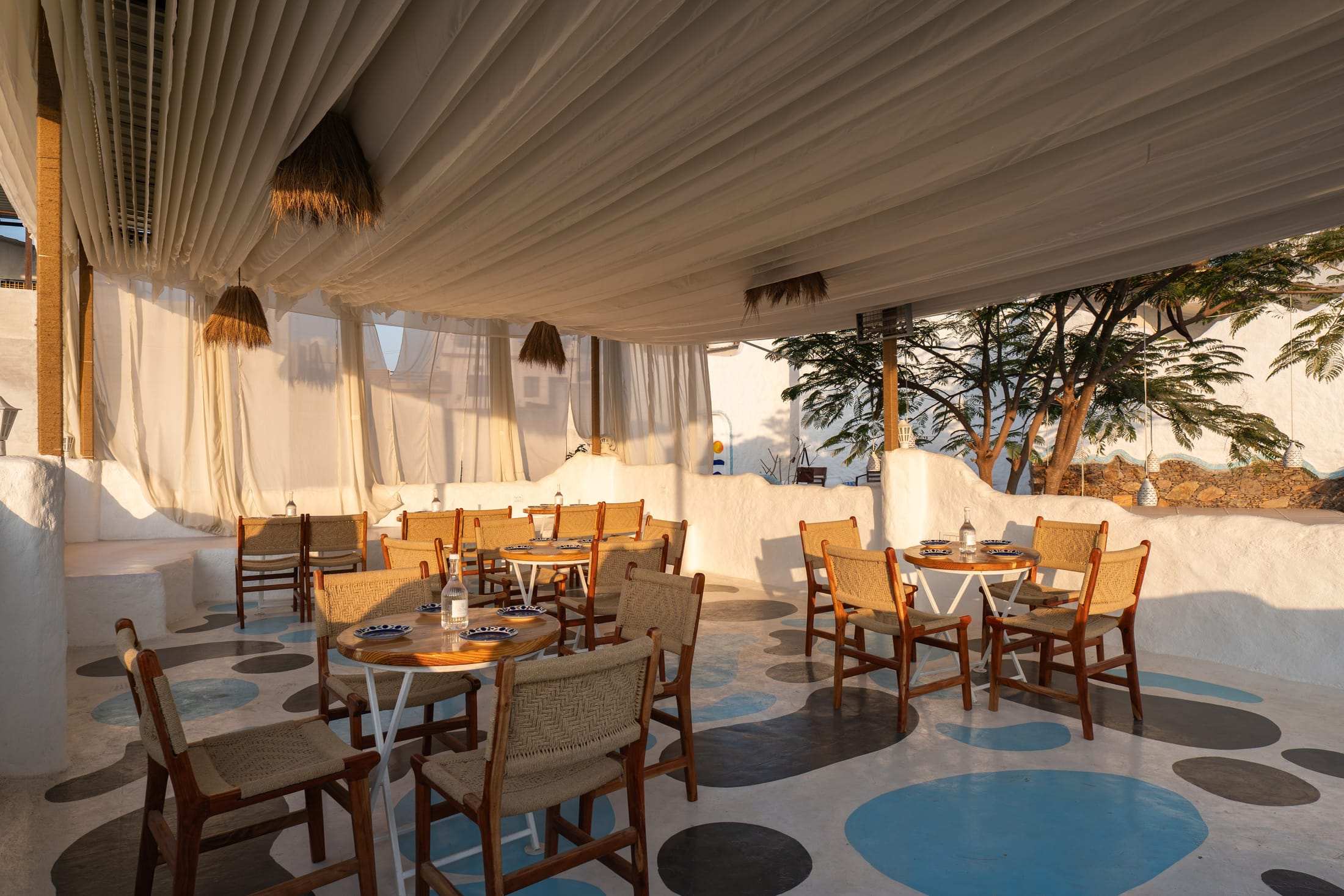 Café seating on playful blue-dot flooring under a canopy
