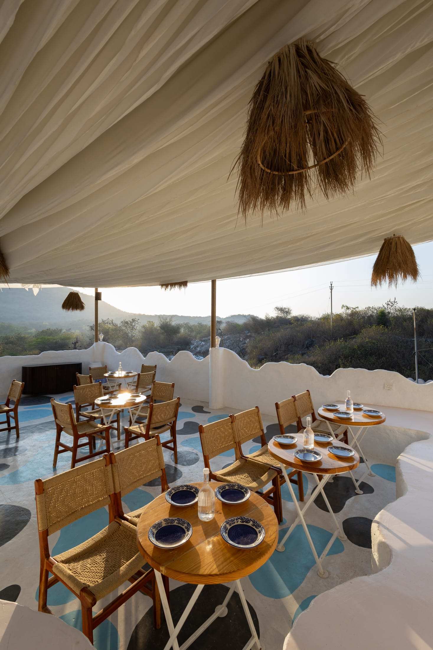 Terrace café tables and cane chairs looking out toward the hills