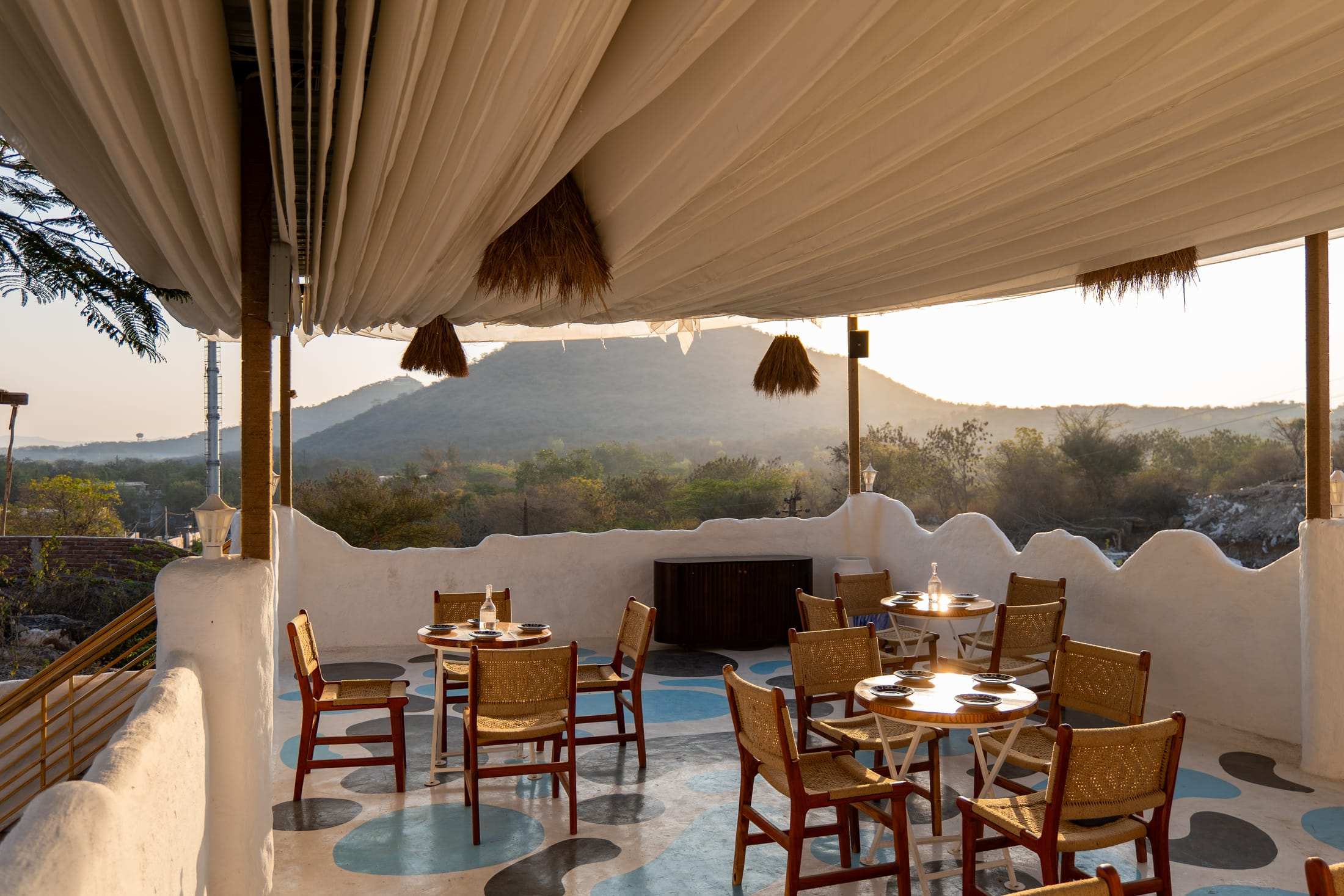 Terrace café table set for dinner with hills in the background